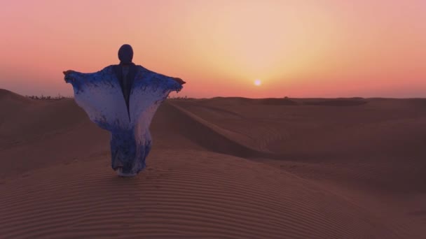Women wearing beautiful blue and white Arab clothes rising her hands at the desert — 비디오