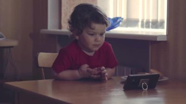 Bu one'ı açın. Yan yana oturan ve her iki evde müzik dinlerken bir akıllı telefon ekranında kendi dikkat odaklama iki farklı yaşında çocuk çok güzel atış.