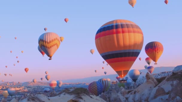 Balony na ogrzane powietrze przelatujące nad górskim krajobrazem Kapadocji, Turcja. — Wideo stockowe