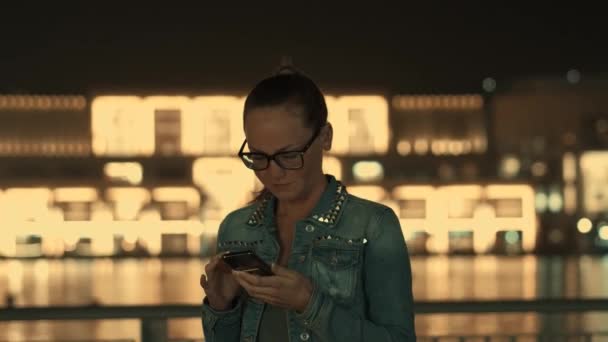 Charmant jong hipster meisje in jas en bril is chatten in sociale netwerken — Stockvideo