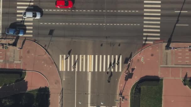 Letecký pohled na lidi, kteří kráčí po přechodu na pěší na křižovatce — Stock video