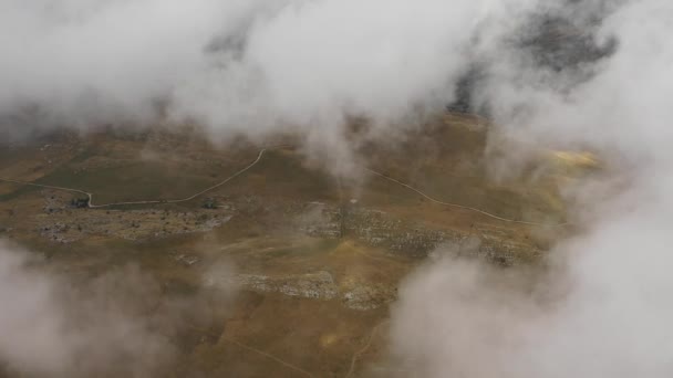 Vista aérea hipnotizante nubes de cúmulos blancos flotan sobre terreno montañoso — Vídeos de Stock