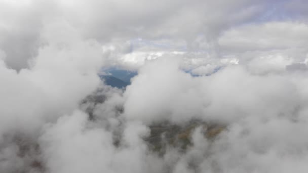 Luftaufnahme hypnotisierende weiße Kumuluswolken schweben über bergigem Gelände — Stockvideo