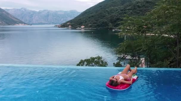 AERIAL. Encantadora joven mujer caucásica rubia en gafas de sol y bañador — Vídeos de Stock