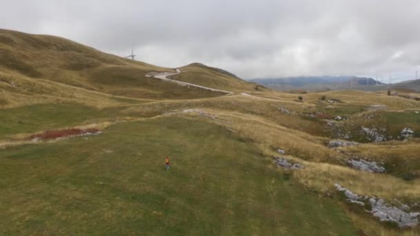 Veduta aerea di un giovane inseguitore turistico solitario che cammina tra le montagne — Video Stock