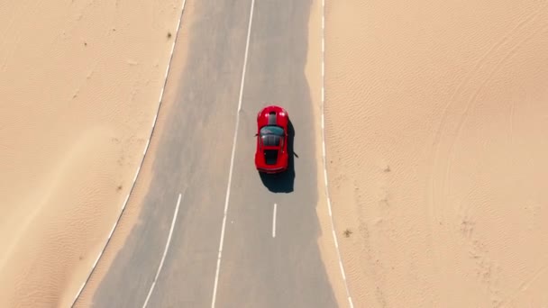 Vista aérea Carro de corrida vermelho andando na estrada do deserto nos Emirados Árabes Unidos . — Vídeo de Stock