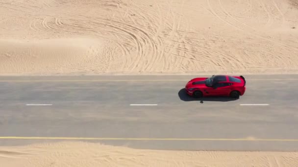 Vista aérea Carro de corrida vermelho andando na estrada do deserto nos Emirados Árabes Unidos . — Vídeo de Stock