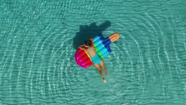 AERIAL. Top view on young woman lying on inflatable mattress — Stock Video
