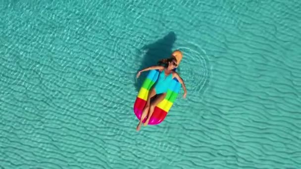 AERIAL. Horní pohled na ženu ležící na vzduchových matracích v moři . — Stock video