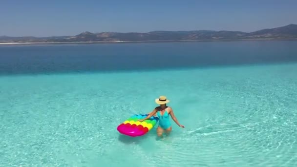 Menina bonita com um colchão no mar. Água pura no mar  . — Vídeo de Stock