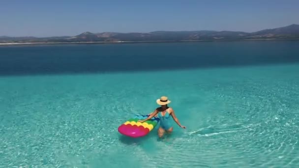 AÉRIAL. Caméra zoom arrière d'une belle fille sur la mer dans un maillot de bain. — Video