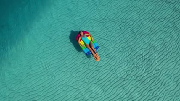 Luchtvaartmaatschappij. Bovenaanzicht van vrouw liggend op luchtmatrassen in de zee . — Stockvideo