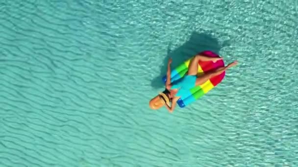 AERIAL. Vista superior de la mujer acostada en colchones de aire en el mar . — Vídeos de Stock