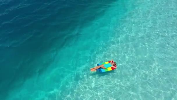 AERIAL. Vista superior de la mujer joven acostada en el colchón inflable — Vídeos de Stock