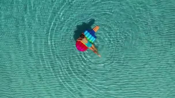 AERİAL. Denizde şişme yataklarda yatan bir kadının arka görüntüsü. . — Stok video