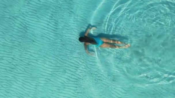 AERIAL.Ein junges Mädchen schwimmt unter Wasser. Kristallklares Wasser.Zeitlupe. — Stockvideo