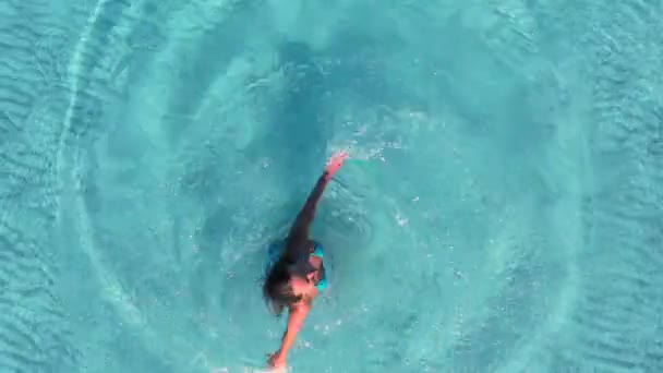 Luchtvaartmaatschappij. Camera zoomen uit van hij meisje is spinnen in kristalhelder zeewater. — Stockvideo