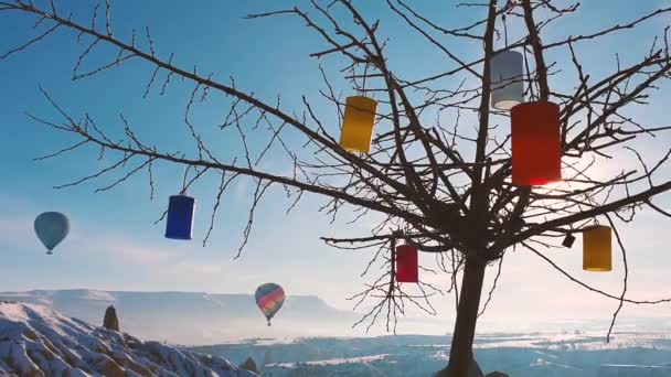 Fliegende Luftballons und ein Baum mit bunten Laternen. — Stockvideo