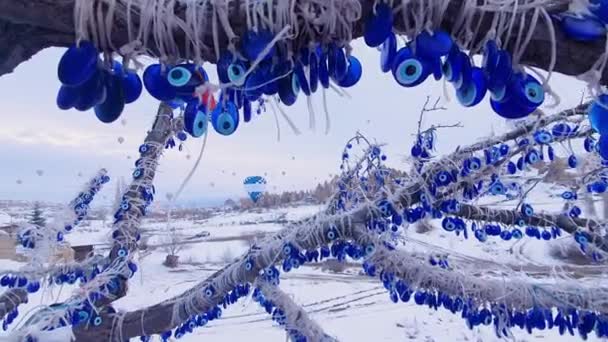 Ett träd med traditionell turkisk souvenir på bakgrunden av flygande varmluftsballonger. Resekoncept efter pandemisk säsong. — Stockvideo