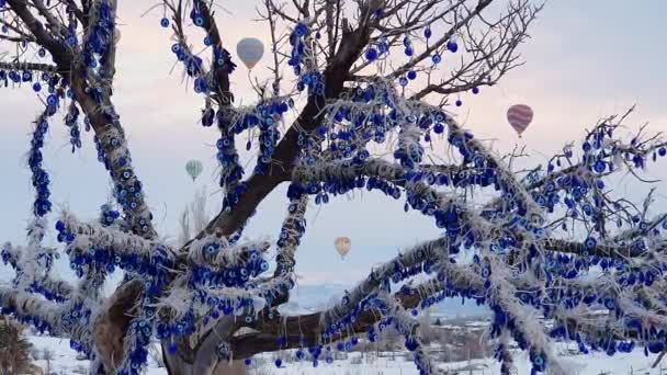 Ett träd med traditionell turkisk souvenir på bakgrunden av flygande varmluftsballonger. Resekoncept efter pandemisk säsong. — Stockvideo