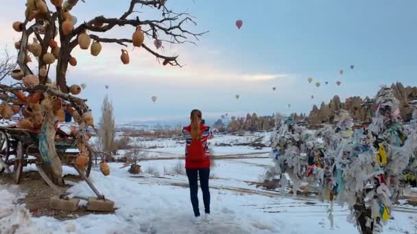 A menina tira fotos de uma bela paisagem no telefone, balões estão voando no fundo. Turquia. — Vídeo de Stock