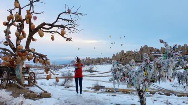 少女は電話で美しい風景の写真を撮る、風船の背景に飛んでいる。トルコ. — ストック動画