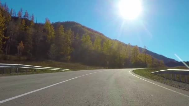 Jazda w dół cichej wiejskiej autostrady w ciągu dnia jesienią. Chuysky TRACT, Siberia, Rosja. — Wideo stockowe