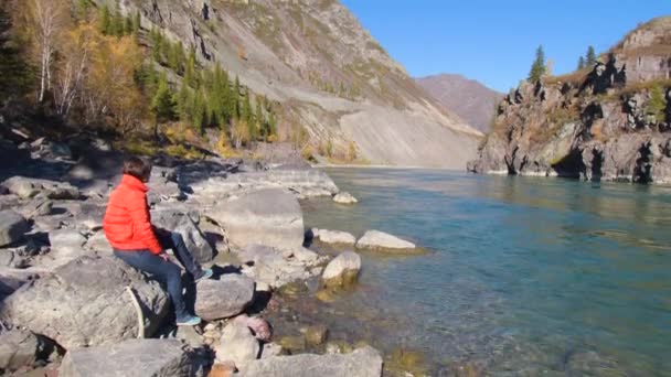 Mulher viajante olhando para canyon natural com vista para o rio da montanha. Conceito de viagem . — Vídeo de Stock