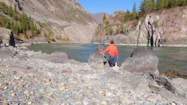 Kadın gezgin dağ nehri manzaralı doğal kanyona bakıyor. Seyahat kavramı