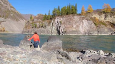 Kadın gezgin dağ nehri manzaralı doğal kanyona bakıyor. Seyahat kavramı.