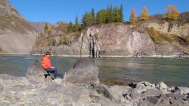 Kadın gezgin dağ nehri manzaralı doğal kanyona bakıyor. Seyahat kavramı.