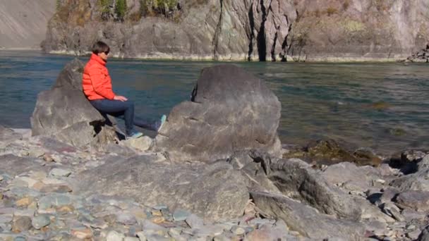 女性の旅行者は、山の川の景色と自然の峡谷を見て。旅行の概念. — ストック動画