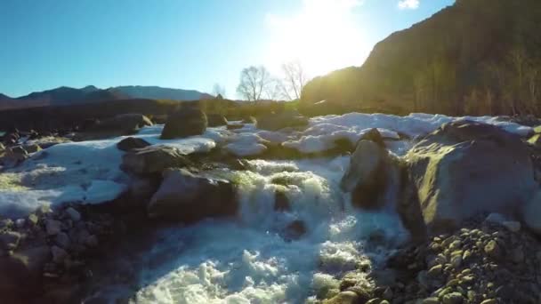 Aguas de manantial en el arroyo, la nieve yace en el valle, el sol brilla — Vídeo de stock