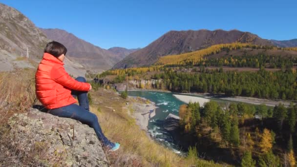 Жінка мандрівник дивиться на природний каньйон з видом на гірську річку. Концепція подорожей . — стокове відео