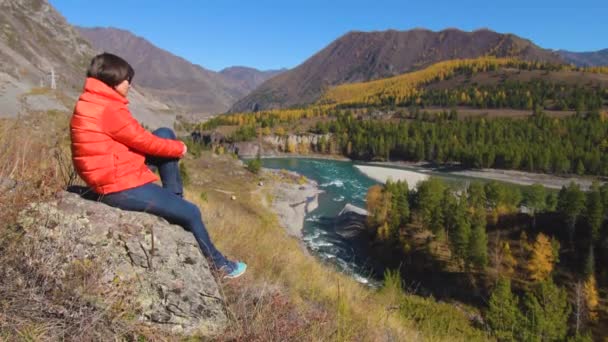 Женщина-путешественница смотрит на природный каньон с видом на горную реку. Концепция путешествия. — стоковое видео
