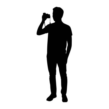 Beyaz bir arkaplana karşı duran siyah bir siluet. O bir tişört, kot pantolon ve ayakkabı giyiyor. Adam kamerayı gözüne dayamış, kamera kayışı da boynuna dolanmış. Bir el kamerayı tutuyor, diğeri de çantasında.