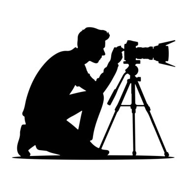 Bir tripoda monte edilmiş profesyonel bir kameranın görüş açısına bakmak için çömelmiş siyah bir siluet. Kişi uzun kollu ve pantolonlu ve elleri kamera kontrollerinin yanında duruyor. Tripodun üç bacağı var.
