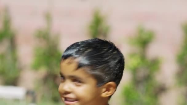 Медленное движение симпатичного маленького мальчика, который стряхивает воду, улыбаясь перед камерой . — стоковое видео