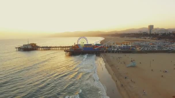 Vackra AERIAL-uttaget på Santa Monica Pier i Kalifornien och Ocean under solnedgången — Stockvideo