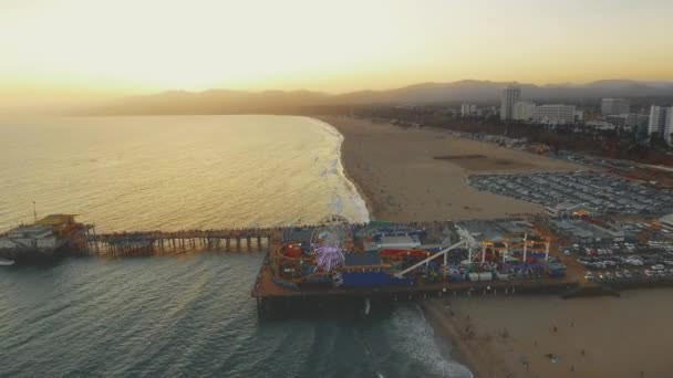 Vackra antenn skott över Santa Monica Pier, Kalifornien och stranden vid solnedgången — Stockvideo