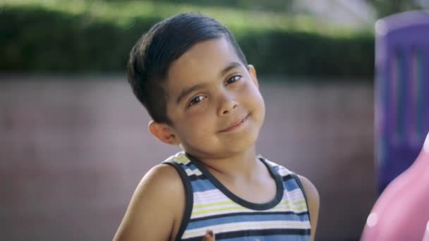 CLose-up de niño mirando a la cámara y sonriendo — Vídeos de Stock