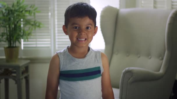 Cámara lenta del niño mirando a la cámara y haciendo rostros — Vídeos de Stock