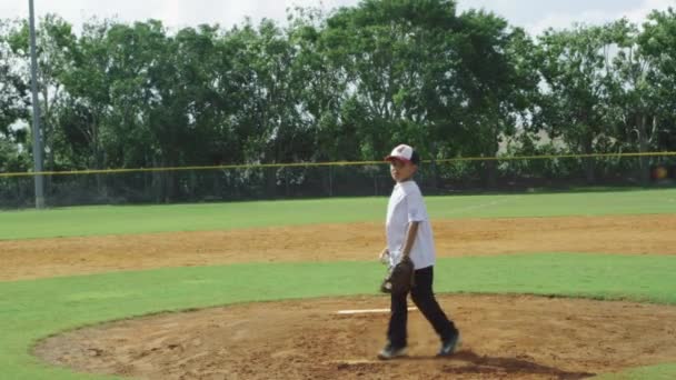 Slow motion van jongen werpen van de bal bij honkbal park — Stockvideo