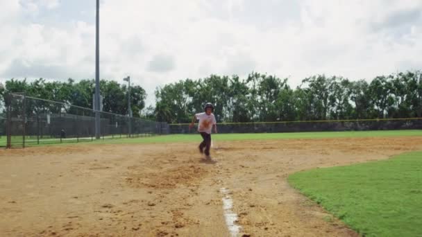 Movimiento lento del niño corriendo desde la tercera base y deslizándose en casa en el parque de béisbol — Vídeos de Stock