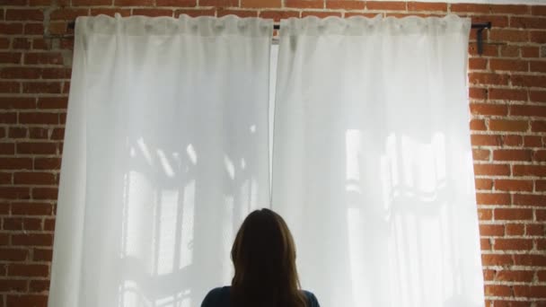 Cool câmera lenta de mulher abrir cortinas brancas por parede de tijolo — Vídeo de Stock