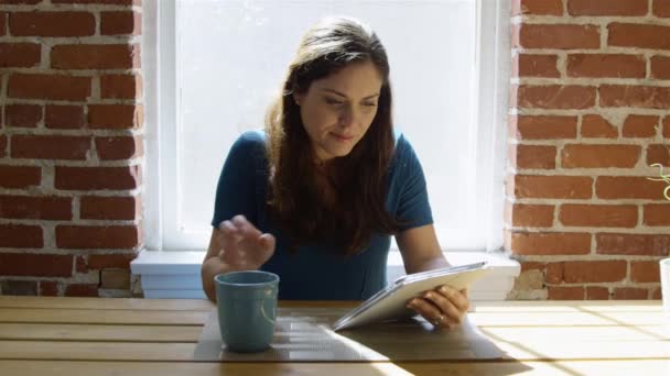 Slow motion van vrouw met behulp van Tablet PC, drinken koffie en glimlachen — Stockvideo