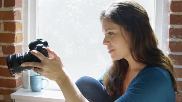 Медленное движение женщины, улыбающейся во время проверки снимков на камеру — стоковое видео