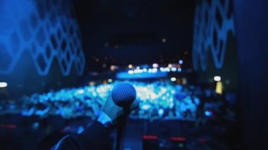 Mikrofon bir stand ile sahnede iken kapma Singer'ın ellerini önünde kalabalık