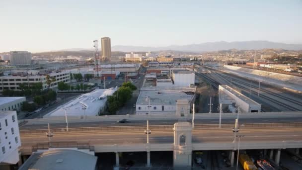 Tiro aéreo de rio, estrada e edifícios no centro de Los Angeles durante o pôr do sol — Vídeo de Stock