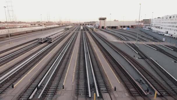 Disparo aéreo sobre las vías del tren por estación — Vídeos de Stock